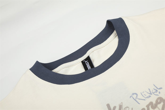 Close-up of the cream shirt's dark ribbed crew neck collar and inner label