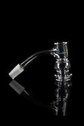 Clear glass bubbler with angled mouthpiece and textured body, reflecting on a black surface.