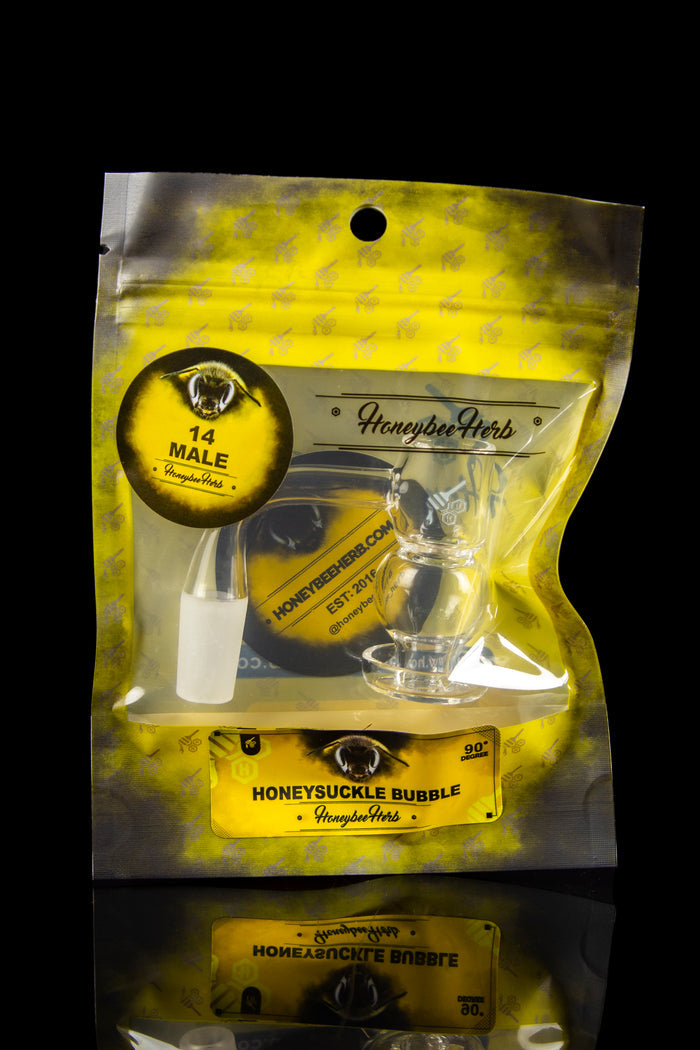 A sealed, gold foil bag labeled "Honeysuckle Bubble" by Honeybee Herb, containing a translucent, amber-colored substance, likely cannabis concentrate or extract.
