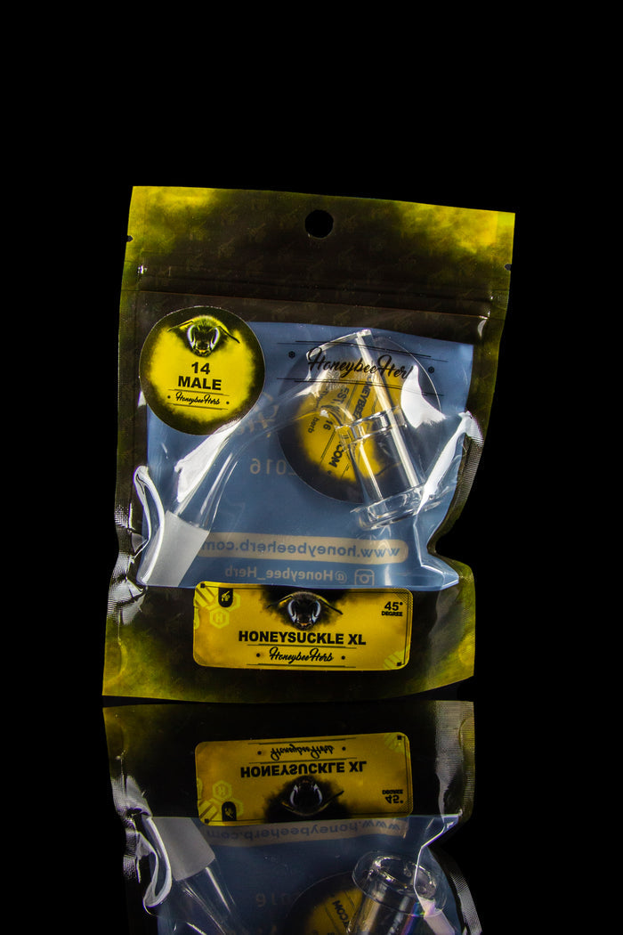 Clear plastic bag containing multiple colorful glass cannabis smoking tips with branding for “Honeysuckle Hers.”