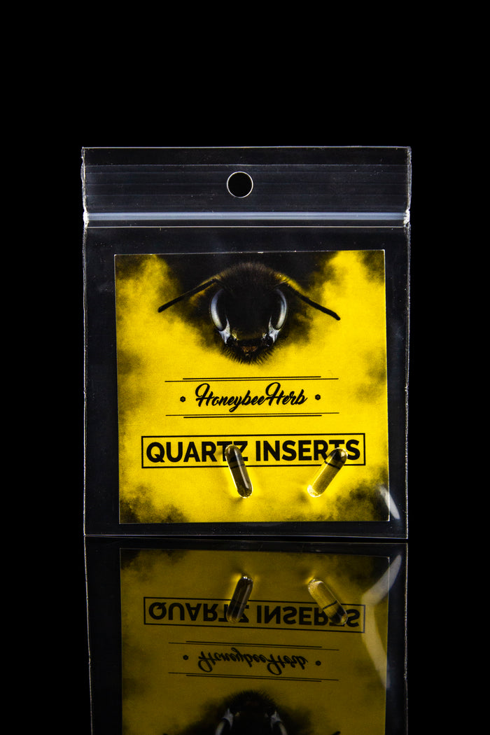 Yellow plastic bag labeled “Honeybee Herb” and “Quartz Inserts” containing two small, dark-colored quartz inserts.