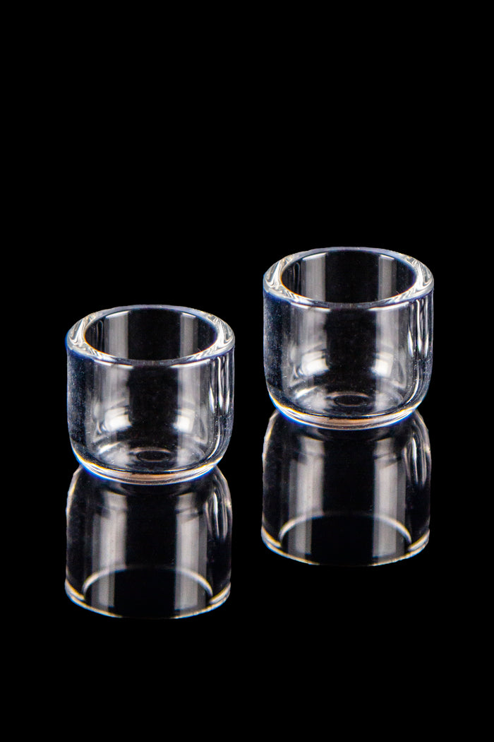 Two clear quartz banger buckets with reflections on a black background.