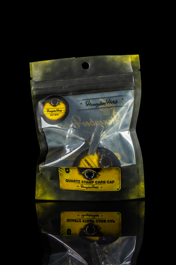 Clear plastic bag containing black “Quartz Stamp Carb Cap” cannabis accessories labeled with “Honeybee Herb” branding.