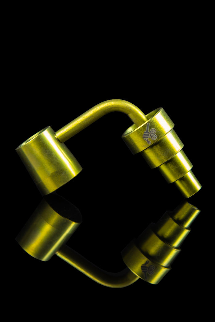 Gold cannabis dab rig with mirrored reflection.