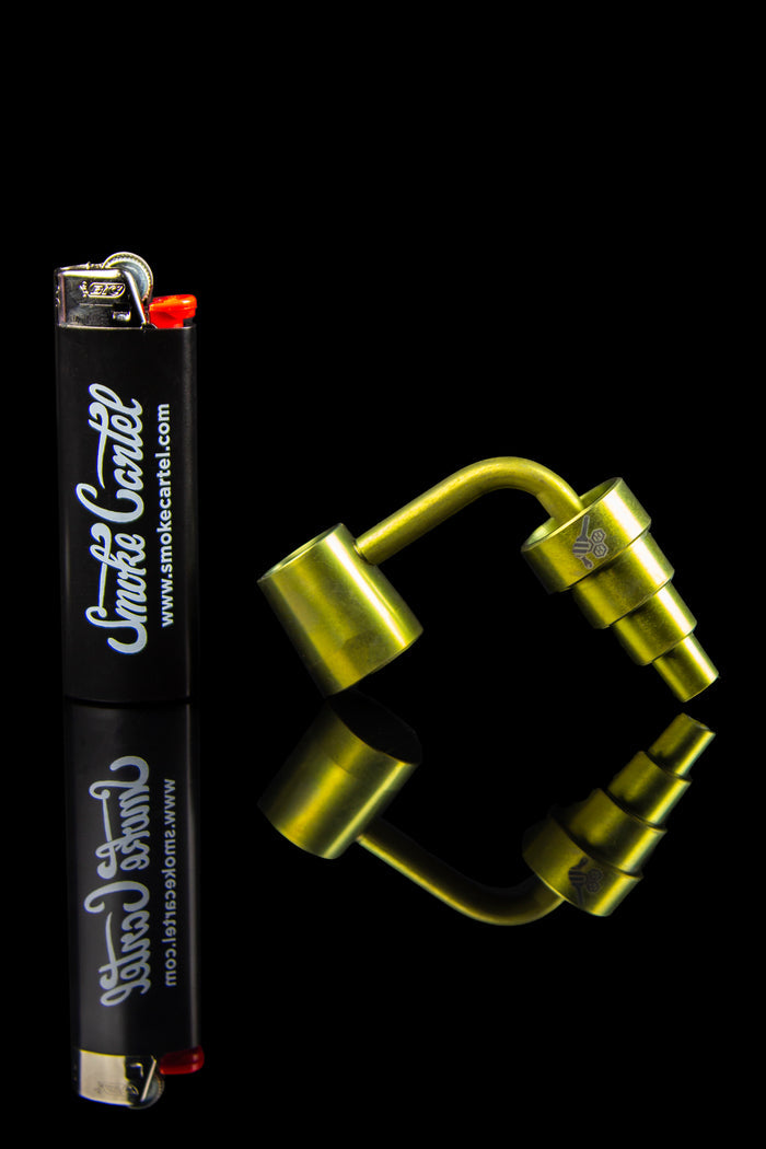 Gold cannabis dab rig with a branded lighter.