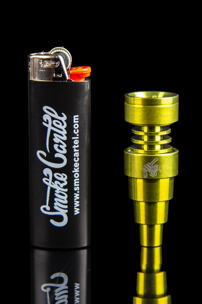 Gold titanium dab nail and lighter with "Smoke Cartel" branding.