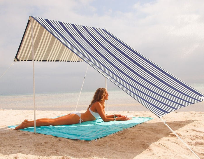 Lovin Summer Sombrilla shade tent with blue and white stripes on sandy beach