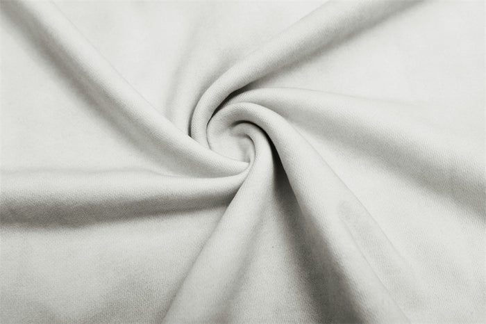 Close-up of the white hoodie fabric twisted to show its smooth, softly textured washed finish