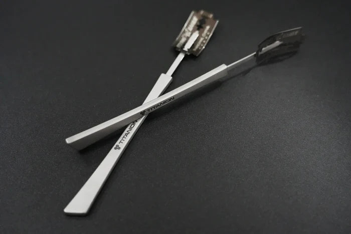 A close-up image of a titanium bread lame, showing its scoring blade and ergonomic handle with "Titanion" logo