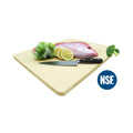 A beige rubber cutting board, 18 x 12 inches, with a knife and some food items like lemon and lettuce on top of it.