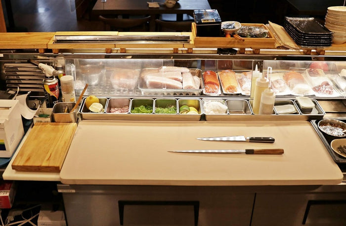 Cutting board shown in sushi station in professional restaurant.