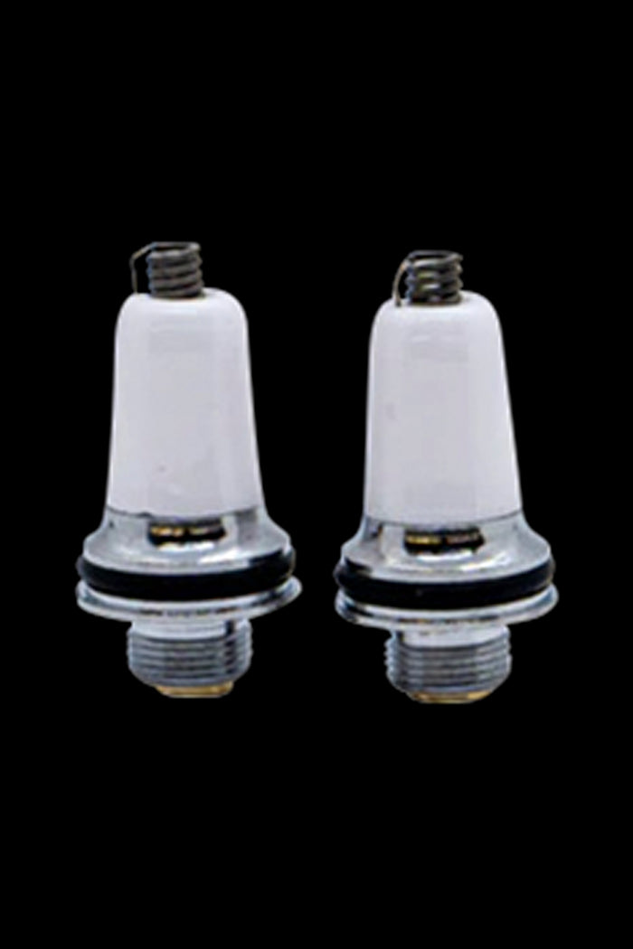 Two white ceramic cannabis oil cartridges with metal bases and mouthpieces against a black background.
