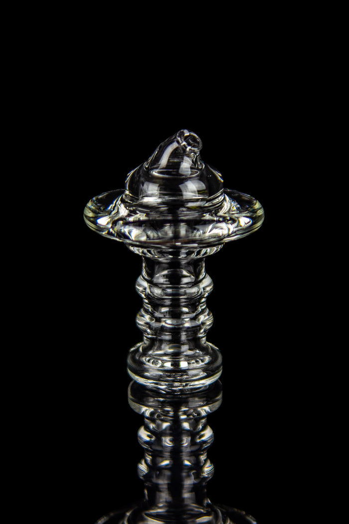 Clear glass dab rig with intricate spiraled design, isolated on black.