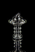 Clear glass dab rig with intricate spiraled design, isolated on black.