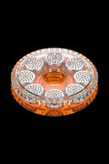 Top-down view of the clear and orange Storz & Bickel Dosing Capsules - 40 Pack arranged in a circular holder against a black background.