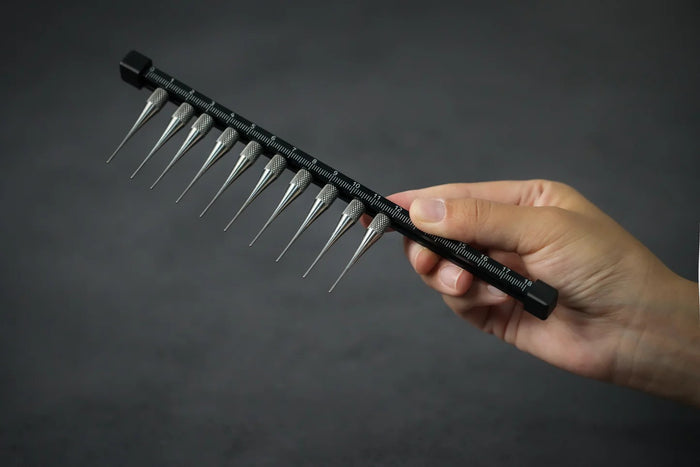 Black Titanium Glaze Comb with 10 Teeth being held on dark background.